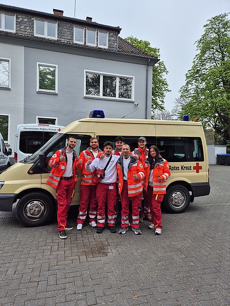 auf dem Foto sind die DRK-Botschafter vor einem DRK-Auto zu sehen